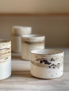 four white and black cups sitting on top of a table