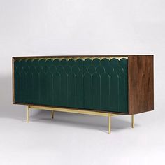 an art deco sideboard with green panels and brass legs