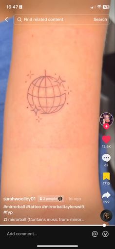 a small tattoo on the wrist that has an image of a globe and stars in it