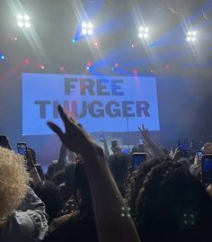 a large group of people at a concert with their cell phones up in the air