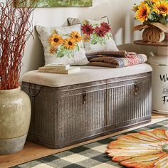 a wooden trunk sitting on top of a floor next to a vase filled with flowers