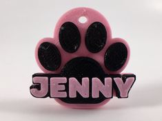 a pink and black dog toy with the word jenny on it's front paws