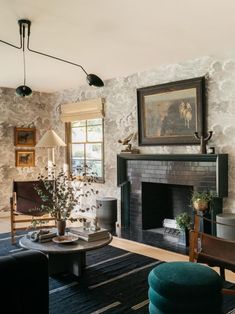 a living room filled with furniture and a fire place next to a painting on the wall