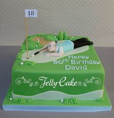 a birthday cake with a person laying on the ground and golf flag sticking out of it