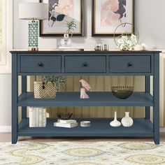 a blue console table with two pictures above it