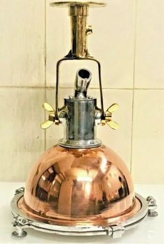 an antique copper plated oil lamp on a white tile wall with metal fittings