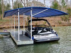 a boat sitting on top of a lake next to a dock with a cover over it