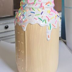 a cup with sprinkles and frosting on it