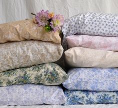 a bunch of pillows stacked on top of each other with a flower in the middle