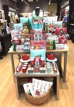 a display in a store filled with lots of christmas items and gifts on top of a wooden table