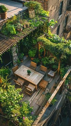 an overhead view of a patio with wooden tables and chairs surrounded by greenery on the roof