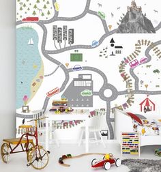 a child's room with a map wallpaper and toy cars on the floor