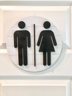 a bathroom sign with two men and a woman on it