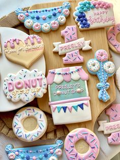 decorated donuts and pastries are displayed on a wooden tray with the words donut shop