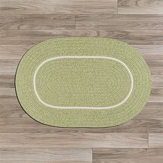 an oval rug on the floor with wood floors in the background and white trimmings