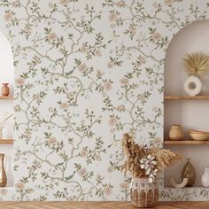 a vase filled with flowers sitting on top of a wooden table next to a wall