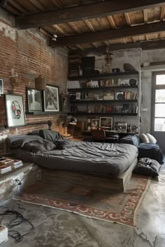 a bed sitting in the middle of a living room next to a book shelf filled with books