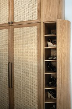 a wooden closet with shoes inside of it