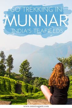 a woman sitting on top of a hill looking out over the tea fields in munnar