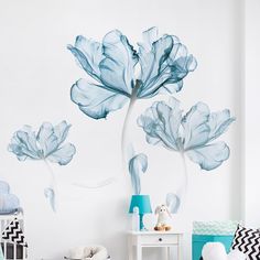 a bedroom decorated in blue and white with flowers on the wall