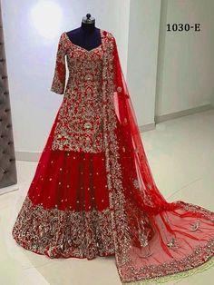 a red bridal gown on display in a room with white walls and flooring