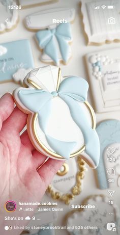 a hand holding a cookie decorated like a baby's pacifier on top of a table