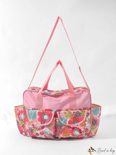 a pink floral duffel bag sitting on top of a white table