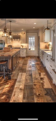 a large kitchen with wooden floors and white cabinets