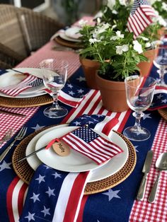 an american flag table setting with place settings and flowers in pots on the tablescape