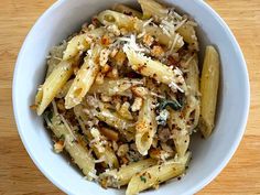 a white bowl filled with pasta and meat