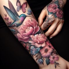 a woman's arm with flowers, butterflies and a hummingbird tattoo on it