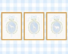 three framed giraffes on a blue and white checkered tablecloth with gold trim