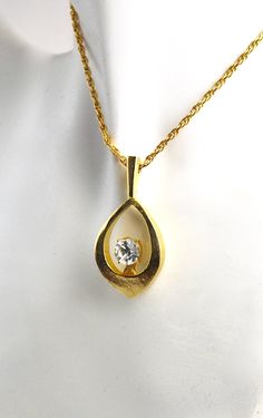 "This beautiful vintage gold toned necklace with a beautiful large round rhinestone hangs from a 24\" vintage chain. Measures 1 5/8\" x 3/4\". Dating back to the 1960's. Never before worn. Wonderful addition to your Vintage Collection!" 1960s Jewelry Necklaces, Gold Pendant Necklace With Stone Setting, Gold Necklace With Stone Setting For Anniversary, Vintage Gold Rhinestone Necklace Gift, Vintage Gold Drop Necklace As Gift, Vintage Gold Drop Necklace For Gifts, Vintage Teardrop Pendant Jewelry For Anniversary, Vintage Hallmarked Teardrop Pendant Jewelry, Vintage Teardrop Pendant Necklace For Formal Occasions