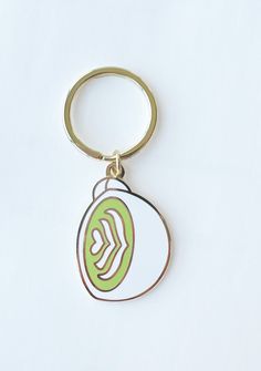 a metal keychain with a green and white design on it's side