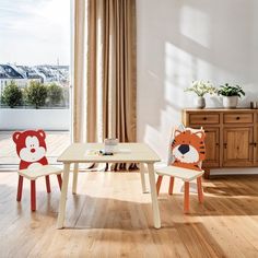 two children's chairs with faces on them sit in front of a small table