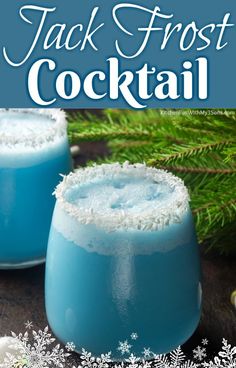 two glasses filled with blue liquid sitting on top of a table next to snow flakes