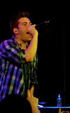 a man singing into a microphone on stage