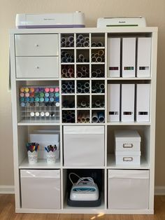 a white bookcase filled with lots of craft supplies