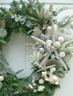 a wreath with starfishs, seashells and greenery