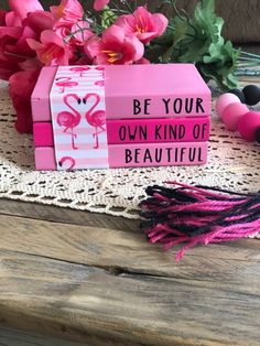 a pink box that says be your own kind of beautiful with flowers in the background