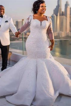 the bride and groom hold hands as they stand on top of a building in front of a cityscape