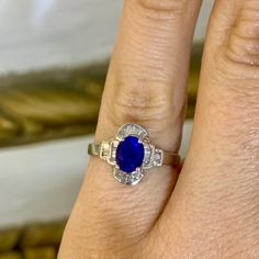 a woman's engagement ring with an oval blue sapphire and baguette diamonds