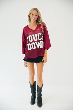 Score a touchdown in style with the Touchdown Maroon Jersey Top. This maroon jersey top features white varsity letters with the word "touchdown" across the front - perfect for any gameday. It's sure to make you the envy of the crowd. MEASUREMENTS: SMALL/MEDIUM MEDIUM/LARGE LARGE/X-LARGE Length 22 1/2" 23 1/2" 24 1/2" Width 22 1/2" 24" 25 1/2" You can find the "CUSTOM TOUCH DOWN JERSEY TOP" here. This is a made-to-order item. All customized orders are currently shipping within 7 business days. To Black Tops For Game Day, Varsity Tops For Fall Sports Events, Varsity Tops For Sports Events In Fall, Varsity Style Tops For Fall Sports Events, Fall Varsity Style Tops For Sports Events, Team-colored Tops For Sports Events In Fall, Sporty Tops For Game Day In Fall, Varsity Tops For Game Day, Collegiate Tops For Football Season Tailgating