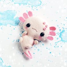 a small stuffed animal laying on top of a blue and white background with water droplets