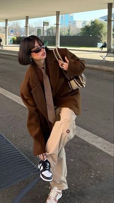 a woman in brown jacket and tie on skateboard