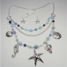 This Beautiful Rhodium Nautical Starfish Seashell Aqua And Blue Beads Sea Life Layered Necklace And Earrings Set Features Aqua, Blue And Rhodium Beads With The Rhodium Sea Horse, Seashells, Sand Dollar And Starfish Charms As Well As Aqua And Blue Beads And Bluish Pearls. The Silver Tone Necklace Is 20 Inches Long With A 2 Inch Extender To 22 Inches And Has A Lobster Claw Clasp For A Secure Fit On Your Neck. The Starfish Pendant Measures 1 1/2 Inches High And 1 1/2 Inches Wide. Cn 5-0032 Bohemian Blue Jewelry With Starfish Charm, Bohemian Blue Starfish Charm Jewelry, Adjustable Blue Starfish Jewelry, Adjustable Blue Jewelry With Starfish Charm, Ocean-inspired Beaded Jewelry, Beach Jewelry With Dangling Beads, Beach Jewelry With Dangling Round Beads, Beach Dangle Beads Jewelry, Bohemian Starfish Charm Jewelry For Jewelry Making