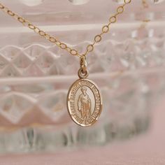 To see this necklace in heirloom-quality 14k solid gold, click here. Our Custom Saint Necklace is the perfect way to keep your favorite saint close to your heart! You can choose from our list of 300+ available saints in the "Saint" dropdown above. We love this necklace paired with our Miraculous Medal Necklace! Looking for more choose-your-own saint pieces? Check out our Custom Saint Collection. Details Available in 14k Gold Filled, Sterling Silver, or 14k Solid Gold 12.7mm x 6.4mm Saint Charm w 14k Gold Pendant With Miraculous Medal, Yellow Gold Miraculous Medal Oval Pendant Necklace, Yellow Gold Oval Pendant Necklace With Miraculous Medal, 14k Gold Miraculous Medal Pendant, 14k Gold Spiritual Miraculous Medal Jewelry And Charms, 14k Gold Spiritual Miraculous Medal Jewelry, Gold Jewelry With Miraculous Medal For Memorial, Gold Miraculous Medal Jewelry For Memorial, 14k Gold Necklace With Miraculous Medal