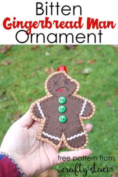 a hand holding up a gingerbread man ornament with buttons on it and the words, biten gingerbread man ornament