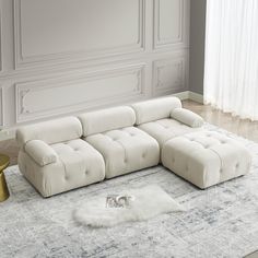 a white sectional sofa sitting on top of a rug