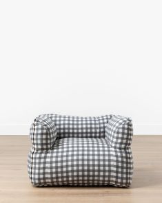 a black and white gingham dog bed sitting on top of a wooden floor